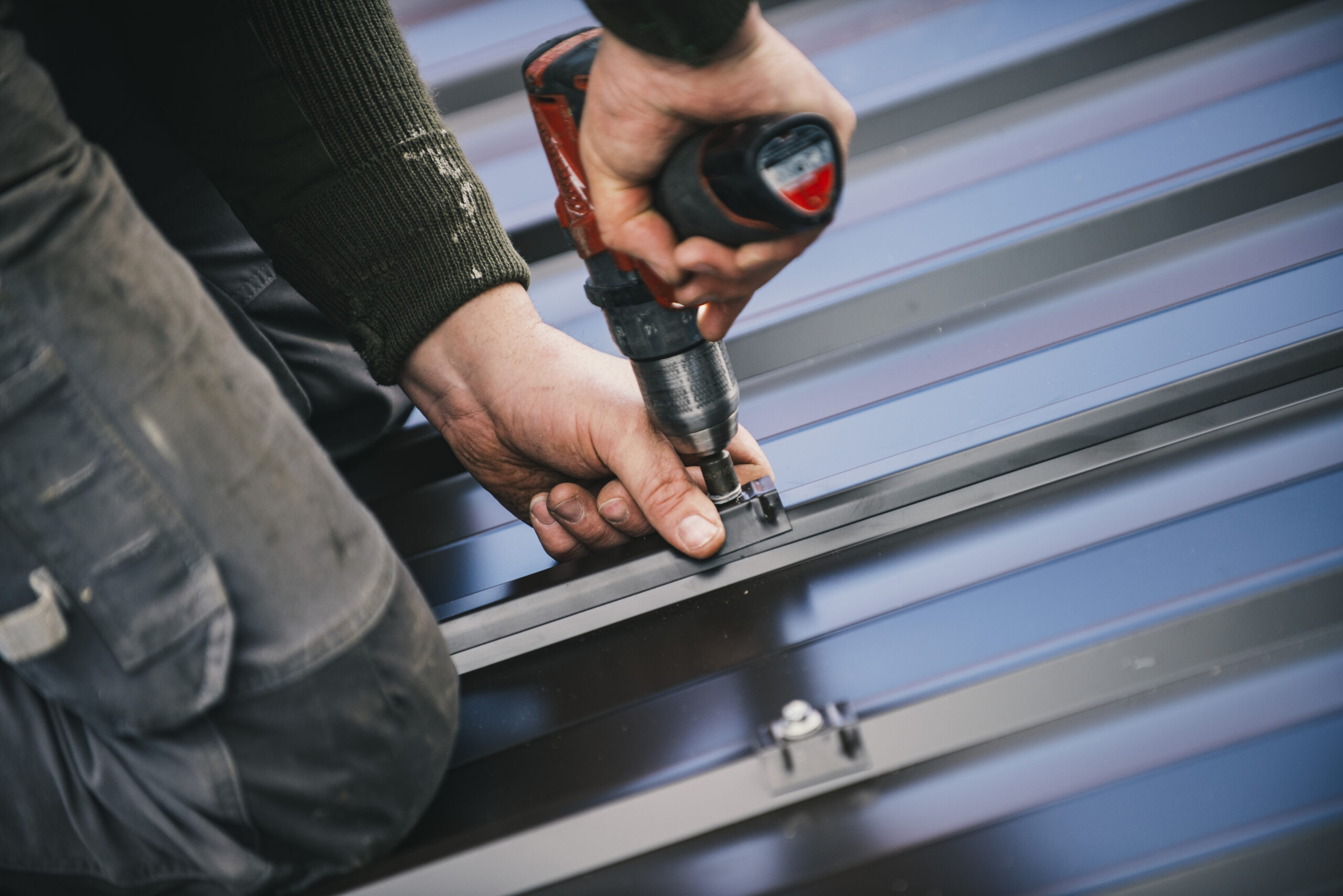 Building contractor is installing metal roofing sheets Couverture
